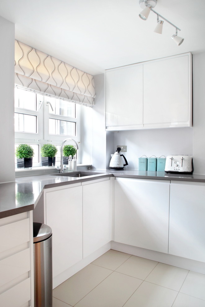 Moderne Küche mit Unterbauwaschbecken, flächenbündigen Schrankfronten und weißen Schränken in London