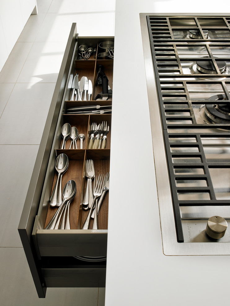 Foto på ett funkis kök, med släta luckor, vita skåp, rostfria vitvaror, klinkergolv i porslin och vitt golv