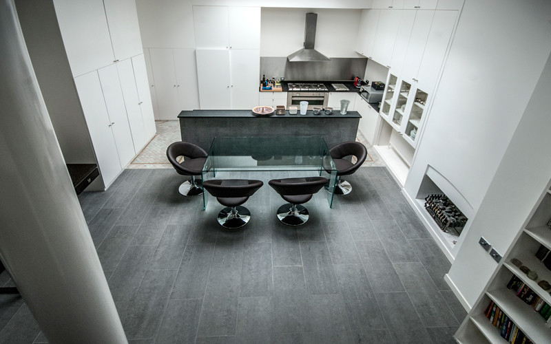 Esempio di una grande cucina minimal con ante lisce, ante bianche, top in granito, paraspruzzi a effetto metallico e top nero