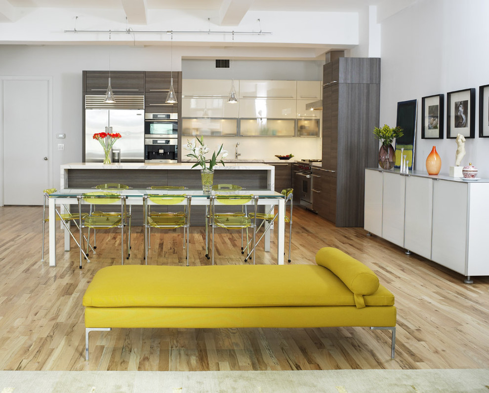 На фото: угловая кухня в современном стиле с плоскими фасадами, техникой из нержавеющей стали, обеденным столом, серыми фасадами и мраморной столешницей