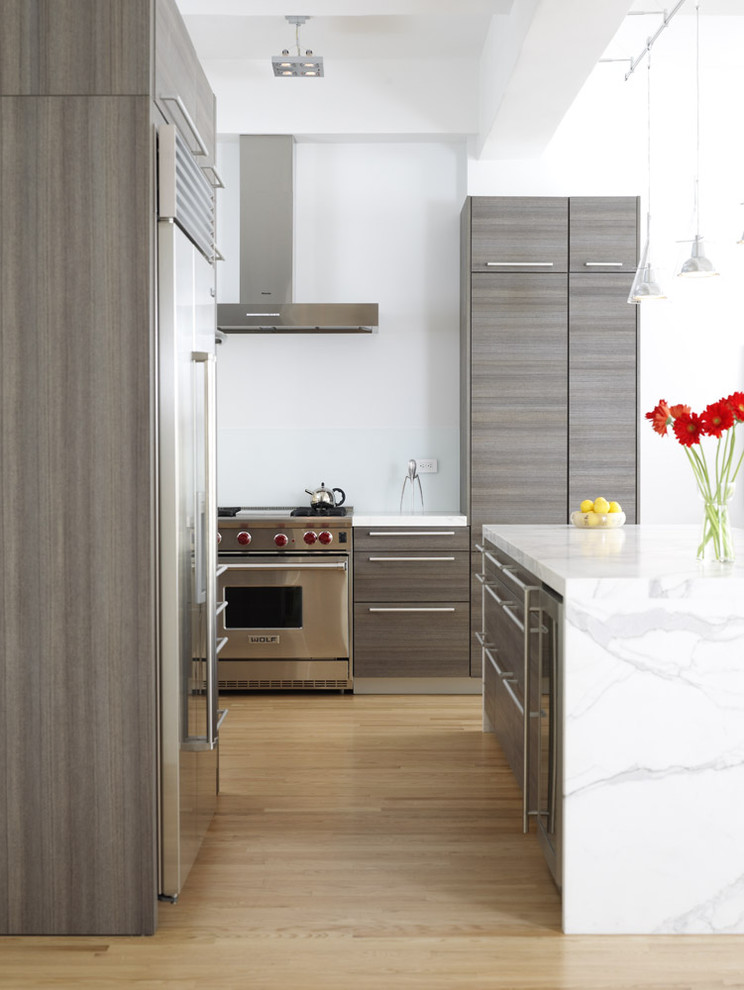 ニューヨークにあるラグジュアリーなコンテンポラリースタイルのおしゃれなキッチン (フラットパネル扉のキャビネット、グレーのキャビネット、大理石カウンター、シルバーの調理設備) の写真