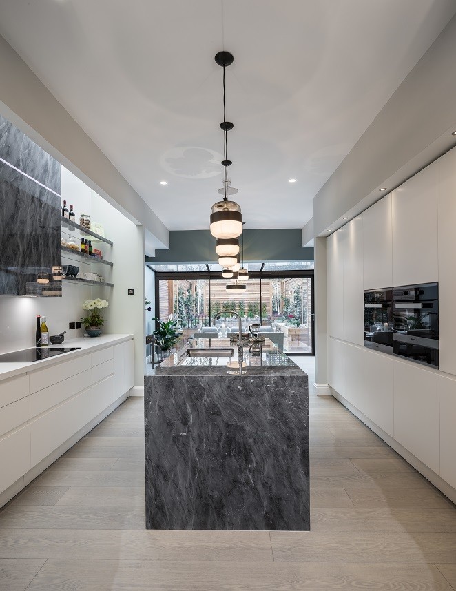 Ispirazione per un cucina con isola centrale minimalista con ante bianche e top in marmo