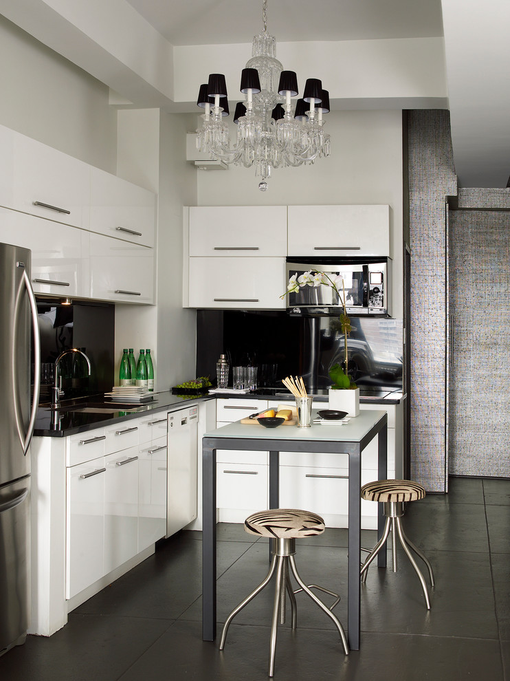 Moderne Küche in L-Form mit Unterbauwaschbecken, flächenbündigen Schrankfronten, weißen Schränken, Küchenrückwand in Schwarz, Küchengeräten aus Edelstahl und Kücheninsel in New York