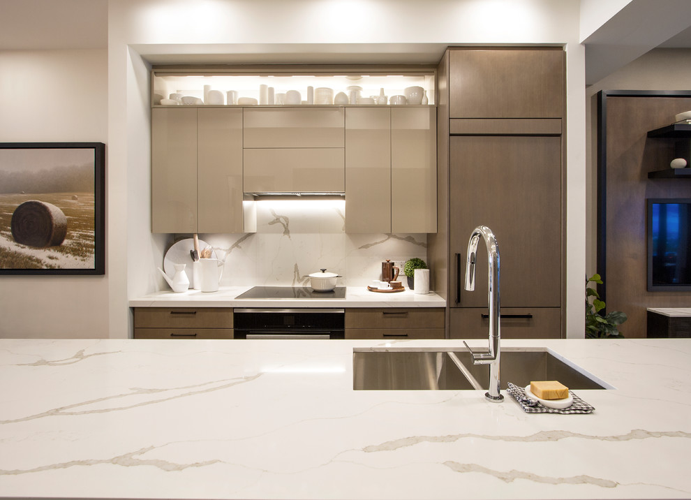 Foto di una piccola cucina moderna con lavello sottopiano, ante lisce, ante beige, top in marmo, paraspruzzi bianco, paraspruzzi in marmo, elettrodomestici da incasso, parquet chiaro e top bianco