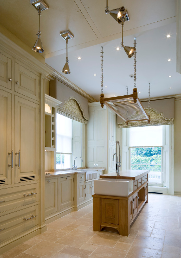 Inspiration for a timeless kitchen remodel in London with raised-panel cabinets and an island
