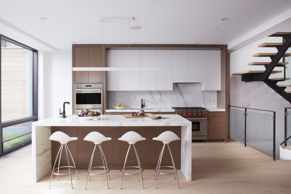 Inspiration for a contemporary kitchen in New York with a submerged sink, flat-panel cabinets, white cabinets, white splashback, stainless steel appliances, light hardwood flooring, an island and beige floors.