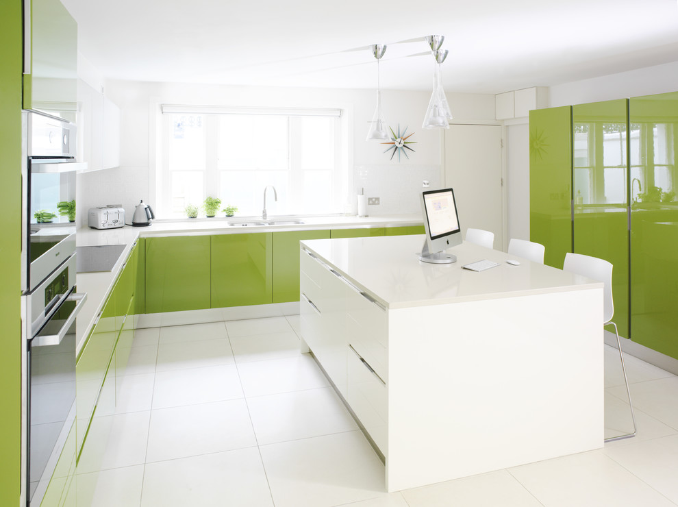 Inredning av ett modernt kök, med en dubbel diskho, släta luckor, gröna skåp, rostfria vitvaror och en köksö