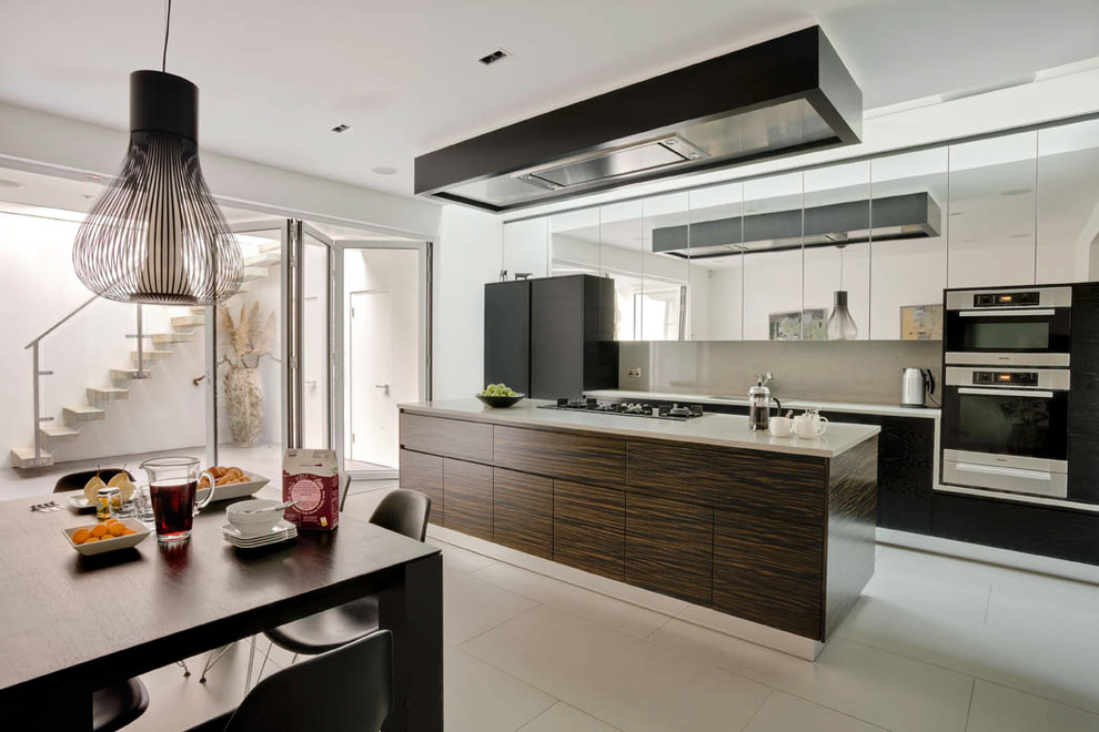 Large contemporary single-wall kitchen/diner in London with flat-panel cabinets, a built-in sink, dark wood cabinets, composite countertops, grey splashback, stone slab splashback, stainless steel appliances, ceramic flooring, an island, grey floors and grey worktops.