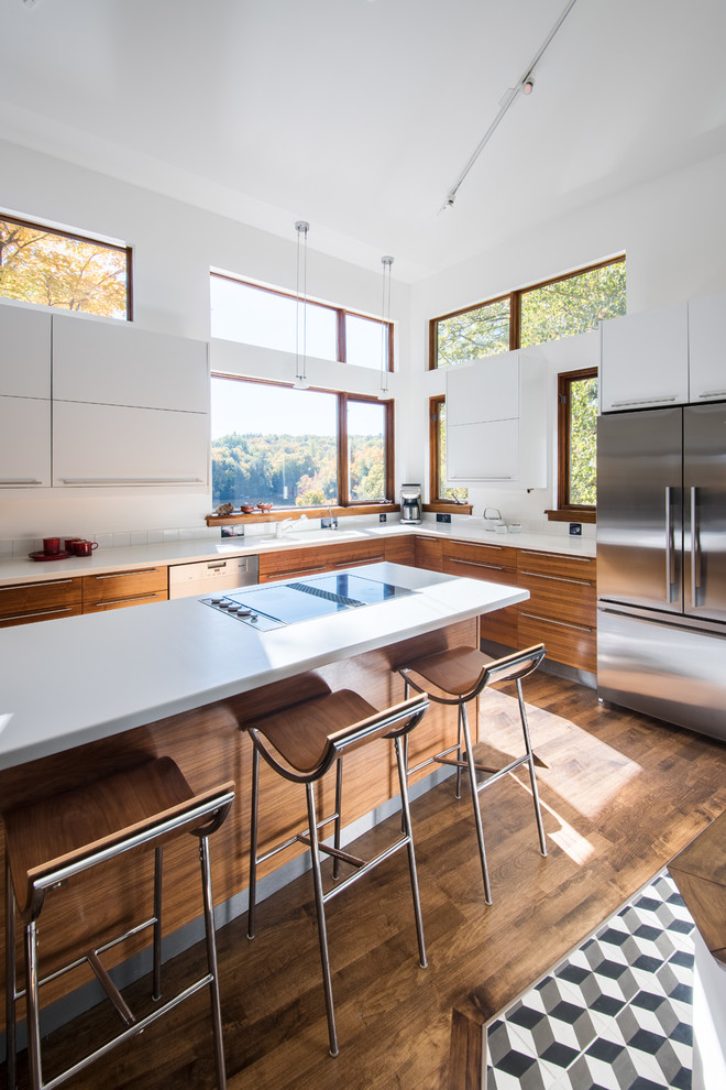 Esempio di una cucina design con ante lisce, ante bianche, paraspruzzi bianco, elettrodomestici in acciaio inossidabile, parquet scuro e pavimento marrone
