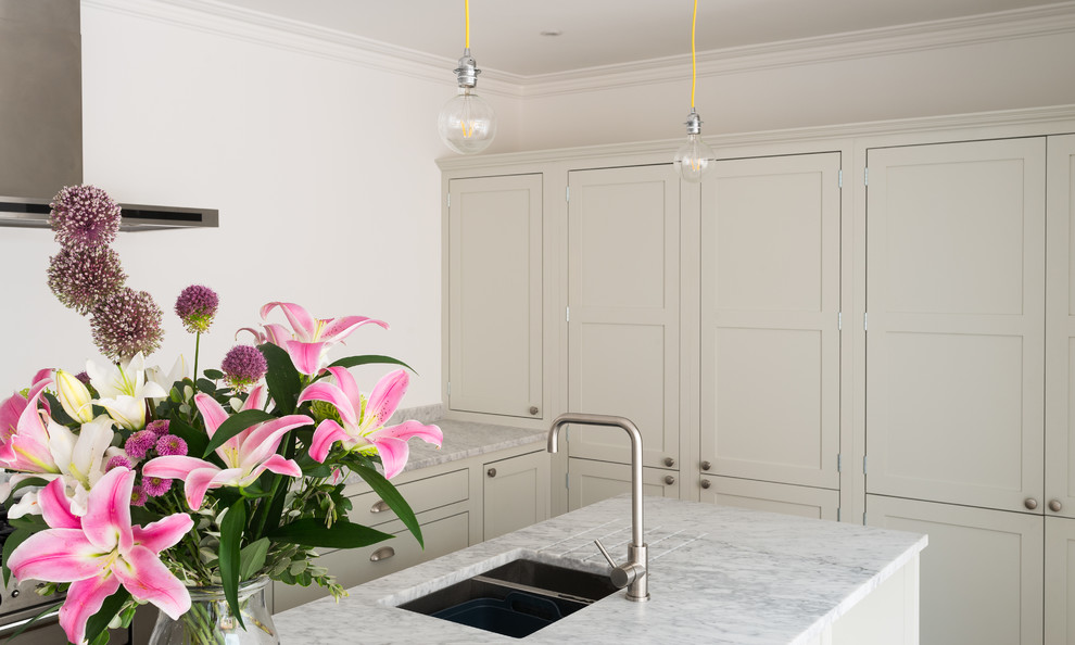 Immagine di una piccola cucina ad ambiente unico tradizionale con ante in stile shaker, ante in legno chiaro, top in marmo e parquet chiaro