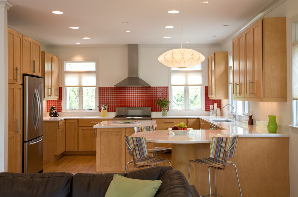 ワシントンD.C.にあるトランジショナルスタイルのおしゃれなキッチン (シェーカースタイル扉のキャビネット、シルバーの調理設備、中間色木目調キャビネット、赤いキッチンパネル) の写真