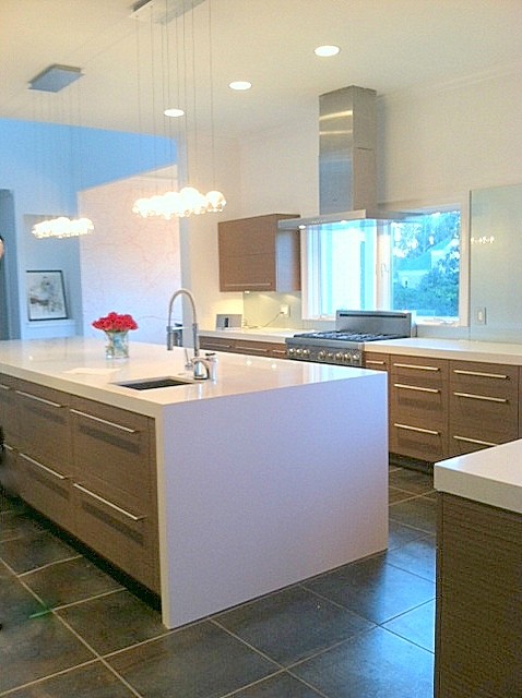 Example of a large minimalist u-shaped porcelain tile eat-in kitchen design in Atlanta with an undermount sink, flat-panel cabinets, medium tone wood cabinets, quartz countertops, white backsplash, glass sheet backsplash, stainless steel appliances and an island