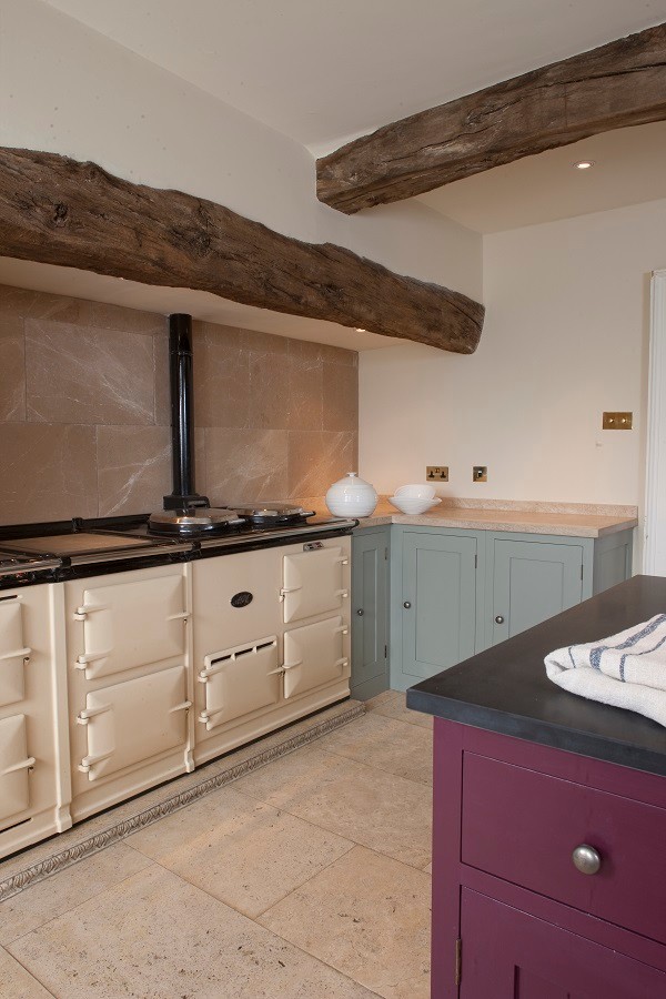 Photo of a medium sized rural galley enclosed kitchen in London with shaker cabinets, granite worktops, coloured appliances, terracotta flooring and an island.