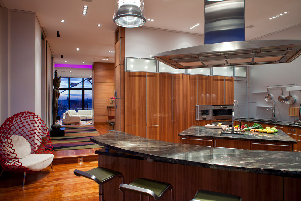 This is an example of a contemporary kitchen in Oklahoma City with a submerged sink, flat-panel cabinets, medium wood cabinets, grey splashback, stainless steel appliances, medium hardwood flooring and multiple islands.