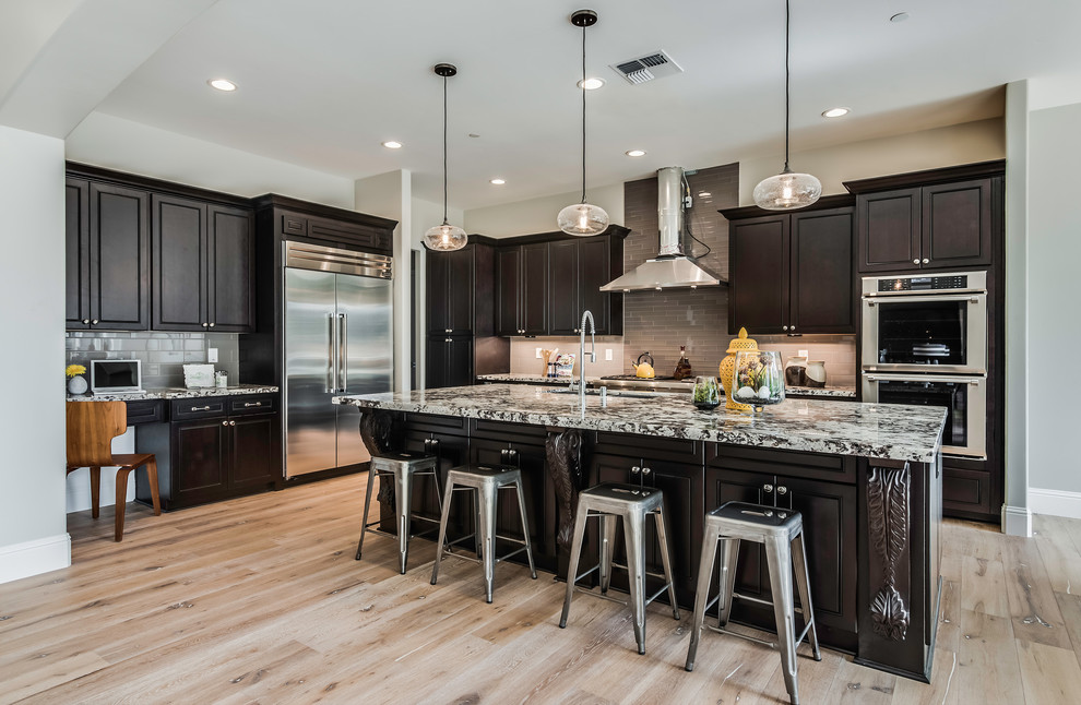 Open concept kitchen - large rustic l-shaped light wood floor and beige floor open concept kitchen idea in Sacramento with an undermount sink, shaker cabinets, dark wood cabinets, laminate countertops, stainless steel appliances and an island