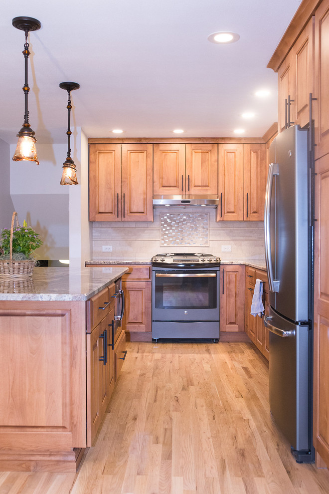Example of a mid-sized classic galley light wood floor open concept kitchen design in Denver with an undermount sink, louvered cabinets, light wood cabinets, granite countertops, stone tile backsplash, stainless steel appliances and an island