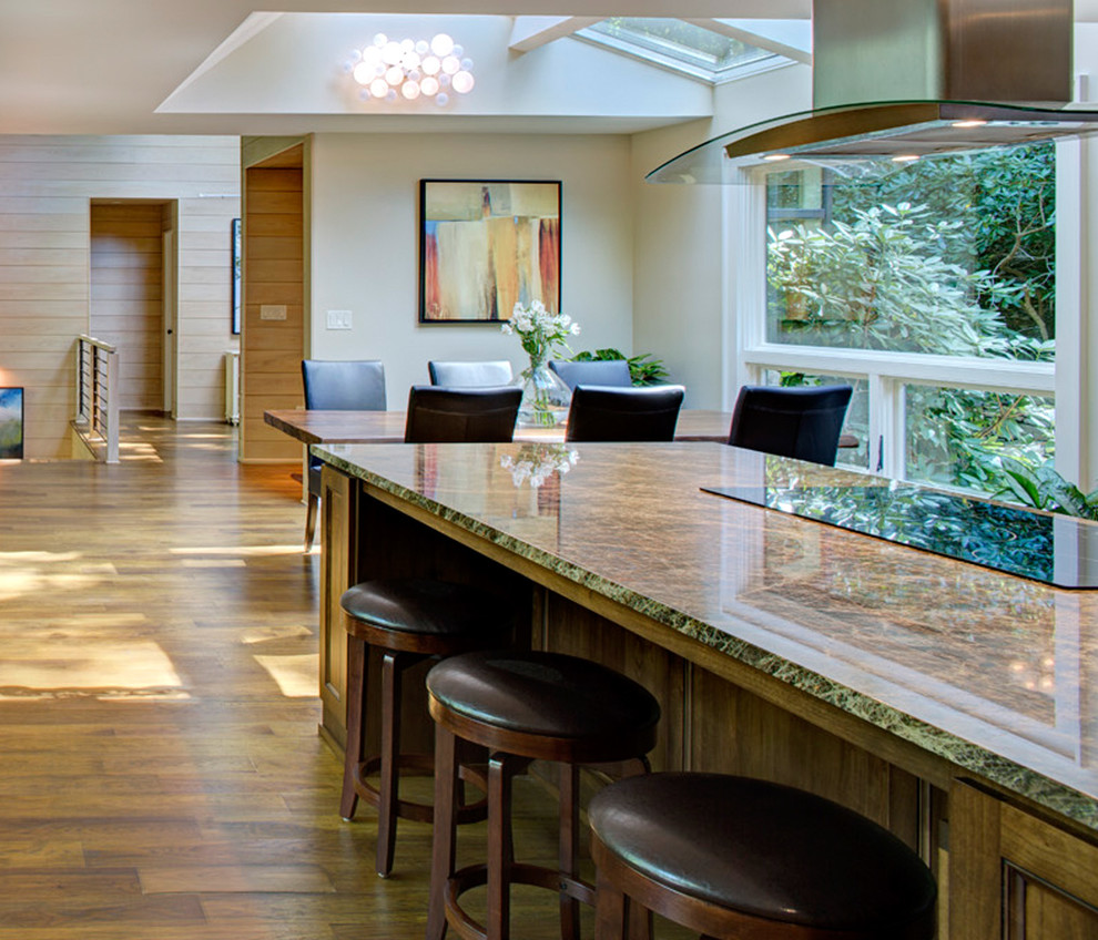 Moderne Wohnküche mit Schrankfronten mit vertiefter Füllung, hellen Holzschränken, Granit-Arbeitsplatte, braunem Holzboden und Kücheninsel in Sonstige