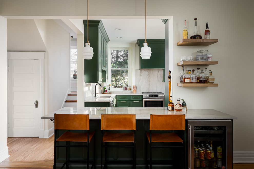 Inredning av ett klassiskt litet grå grått kök, med en enkel diskho, luckor med infälld panel, gröna skåp, bänkskiva i kvartsit, grått stänkskydd, stänkskydd i sten, rostfria vitvaror, mellanmörkt trägolv och en halv köksö