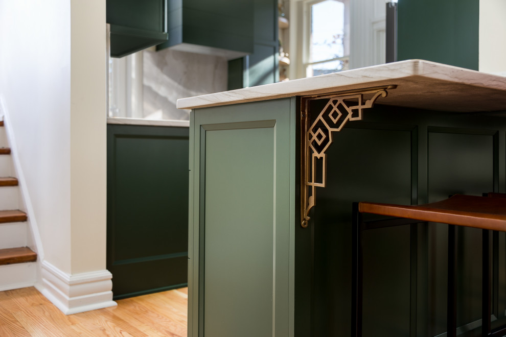 Bild på ett litet vintage grå grått kök, med en enkel diskho, luckor med infälld panel, gröna skåp, bänkskiva i kvartsit, grått stänkskydd, stänkskydd i sten, rostfria vitvaror, mellanmörkt trägolv och en halv köksö