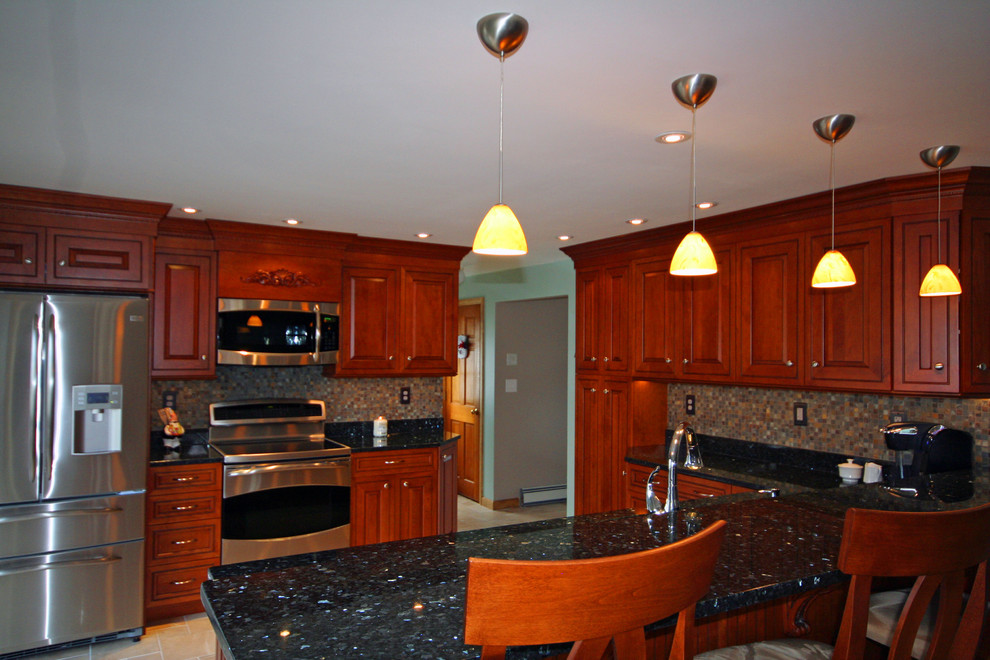 Example of a mid-sized classic u-shaped ceramic tile eat-in kitchen design in Boston with an undermount sink, raised-panel cabinets, medium tone wood cabinets, granite countertops, multicolored backsplash, mosaic tile backsplash, stainless steel appliances and a peninsula