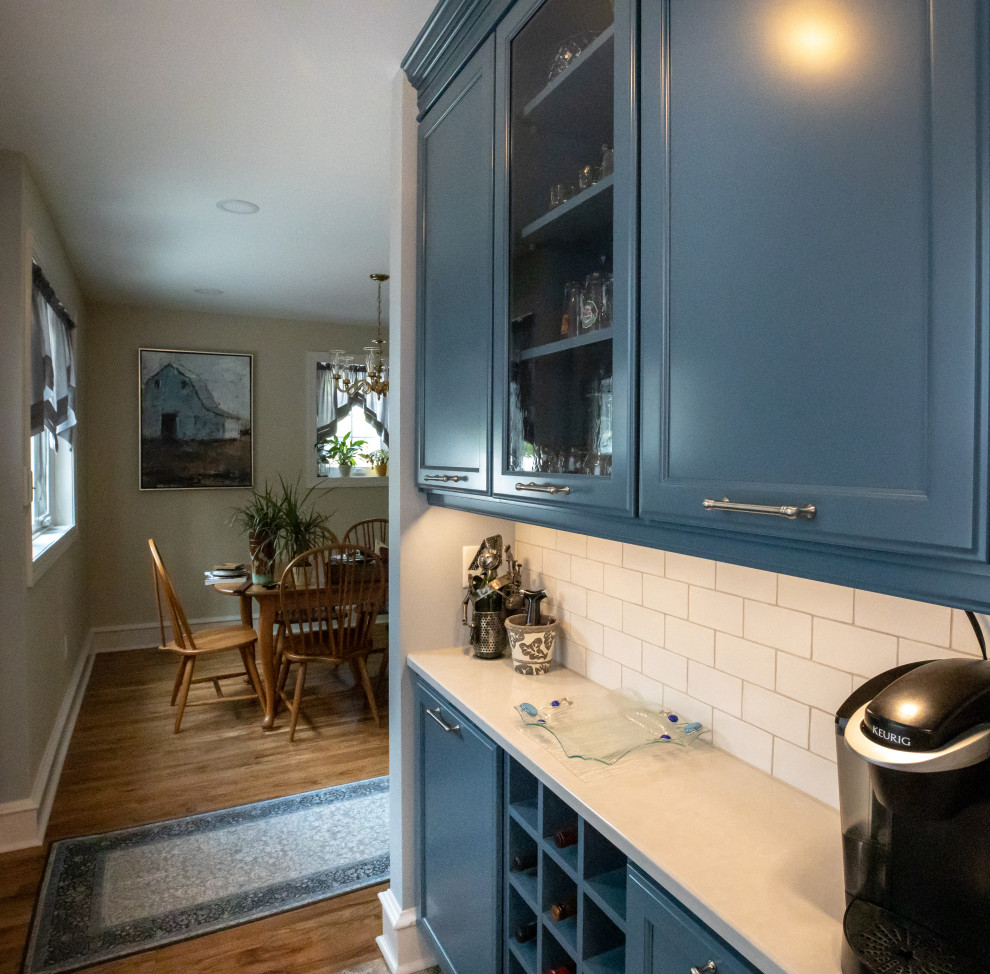 Idéer för att renovera ett mellanstort vintage vit vitt kök, med en rustik diskho, skåp i shakerstil, blå skåp, bänkskiva i kvarts, vitt stänkskydd, stänkskydd i keramik, rostfria vitvaror och klinkergolv i porslin