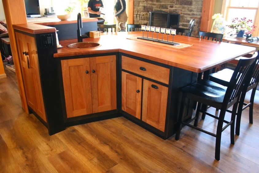 Immagine di una cucina chic di medie dimensioni con lavello a vasca singola, ante lisce, ante nere, top in legno e pavimento in legno massello medio