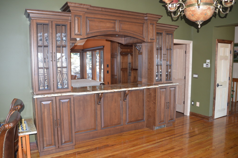 Ejemplo de cocina comedor tradicional con armarios con paneles con relieve, puertas de armario de madera en tonos medios y encimera de granito