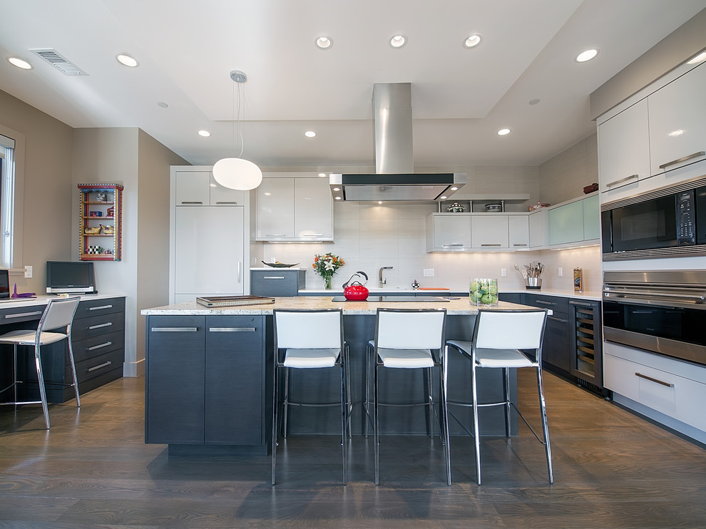 Cette image montre une cuisine grise et blanche design en L avec un placard à porte plane, des portes de placard grises, une crédence blanche et un électroménager en acier inoxydable.