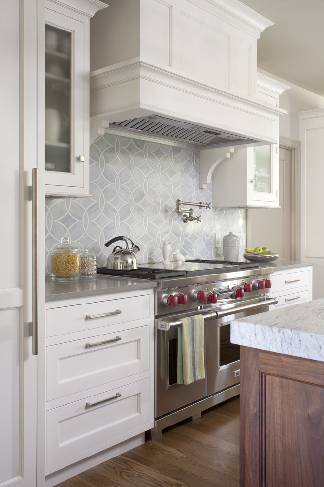 デンバーにあるトランジショナルスタイルのおしゃれなキッチン (シルバーの調理設備、落し込みパネル扉のキャビネット、白いキャビネット、青いキッチンパネル、クオーツストーンカウンター) の写真
