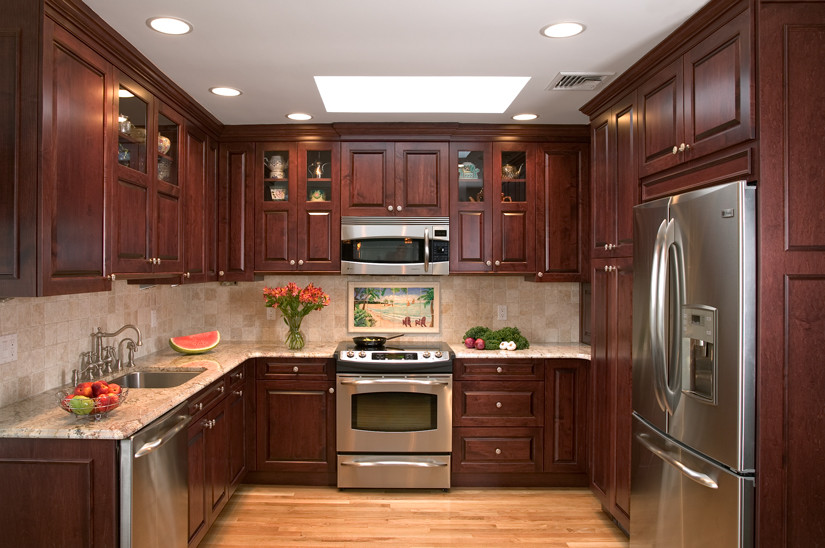 Inspiration for a mid-sized timeless u-shaped medium tone wood floor kitchen remodel in New York with a single-bowl sink, raised-panel cabinets, dark wood cabinets, granite countertops, beige backsplash, ceramic backsplash and stainless steel appliances