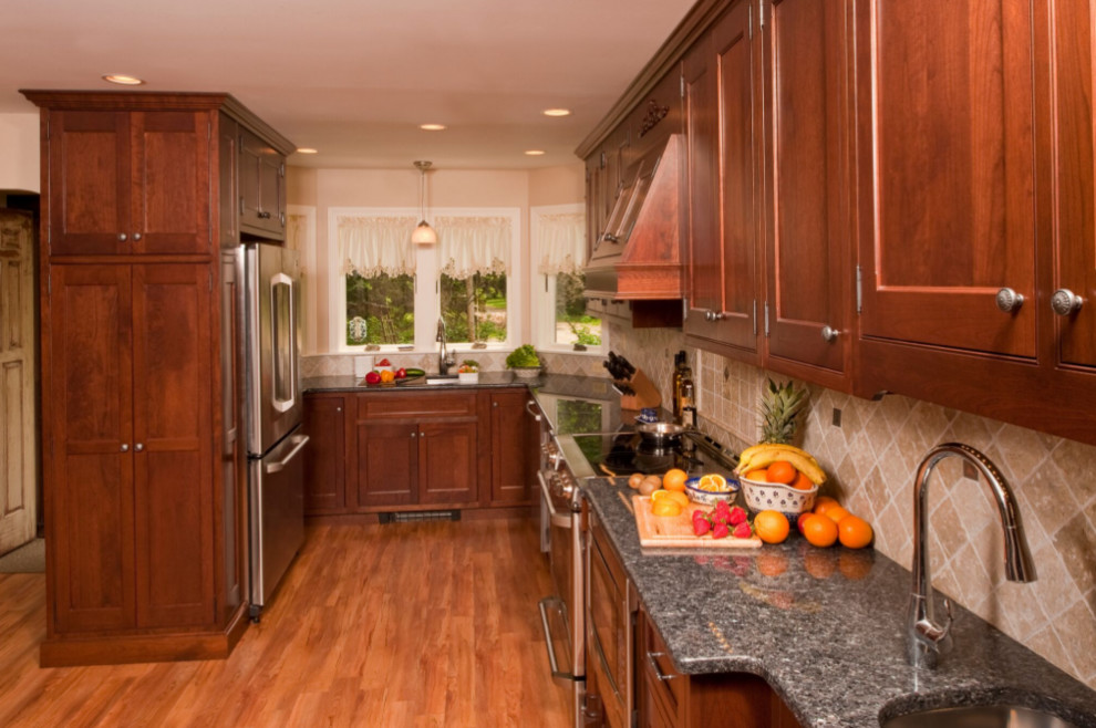 Eat-in kitchen - large traditional u-shaped medium tone wood floor and brown floor eat-in kitchen idea in Boston with an undermount sink, beaded inset cabinets, dark wood cabinets, granite countertops, gray backsplash, stone tile backsplash, stainless steel appliances and no island