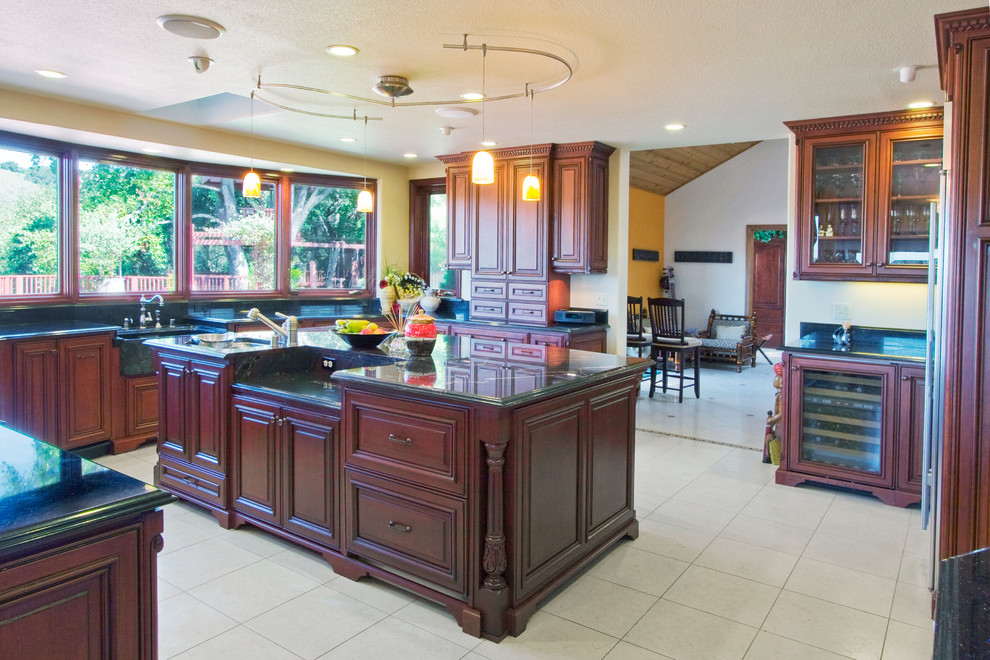 Photo of a large traditional u-shaped enclosed kitchen in San Francisco with a submerged sink, raised-panel cabinets, dark wood cabinets, quartz worktops, stainless steel appliances, ceramic flooring, an island and beige floors.