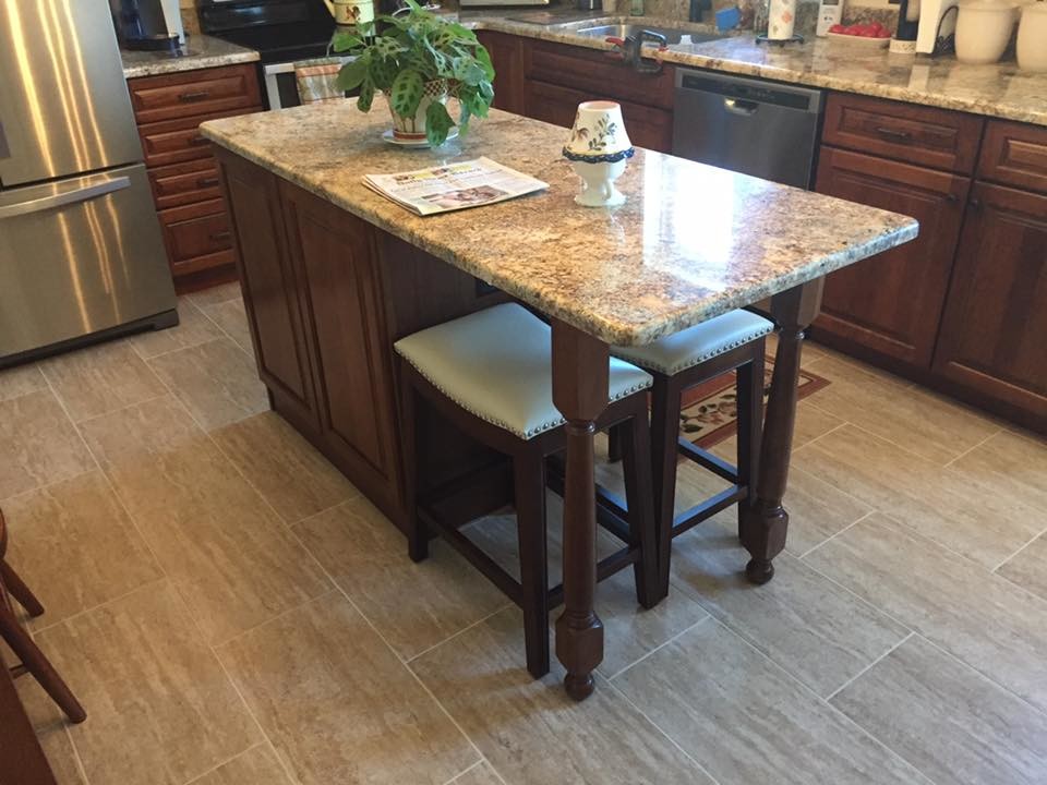 Mid-sized elegant l-shaped ceramic tile and beige floor eat-in kitchen photo in Other with an undermount sink, recessed-panel cabinets, brown cabinets, granite countertops, stainless steel appliances and an island