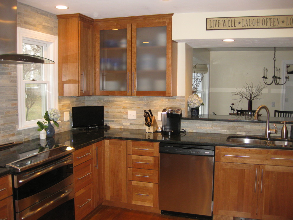 Example of a classic u-shaped medium tone wood floor eat-in kitchen design in Boston with an undermount sink, shaker cabinets, medium tone wood cabinets, granite countertops, gray backsplash, stone tile backsplash, stainless steel appliances, a peninsula and black countertops