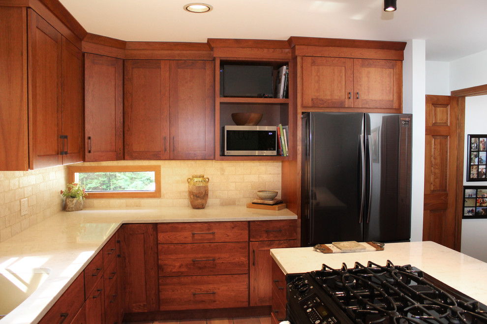 Example of a transitional l-shaped terra-cotta tile and red floor eat-in kitchen design in Other with an undermount sink, shaker cabinets, medium tone wood cabinets, quartz countertops, beige backsplash, travertine backsplash, stainless steel appliances, an island and beige countertops