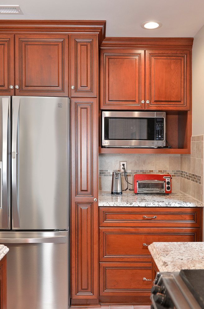 Exempel på ett mellanstort klassiskt grå grått kök, med en undermonterad diskho, luckor med upphöjd panel, skåp i mellenmörkt trä, granitbänkskiva, grått stänkskydd, stänkskydd i keramik, rostfria vitvaror, klinkergolv i keramik, en köksö och rosa golv