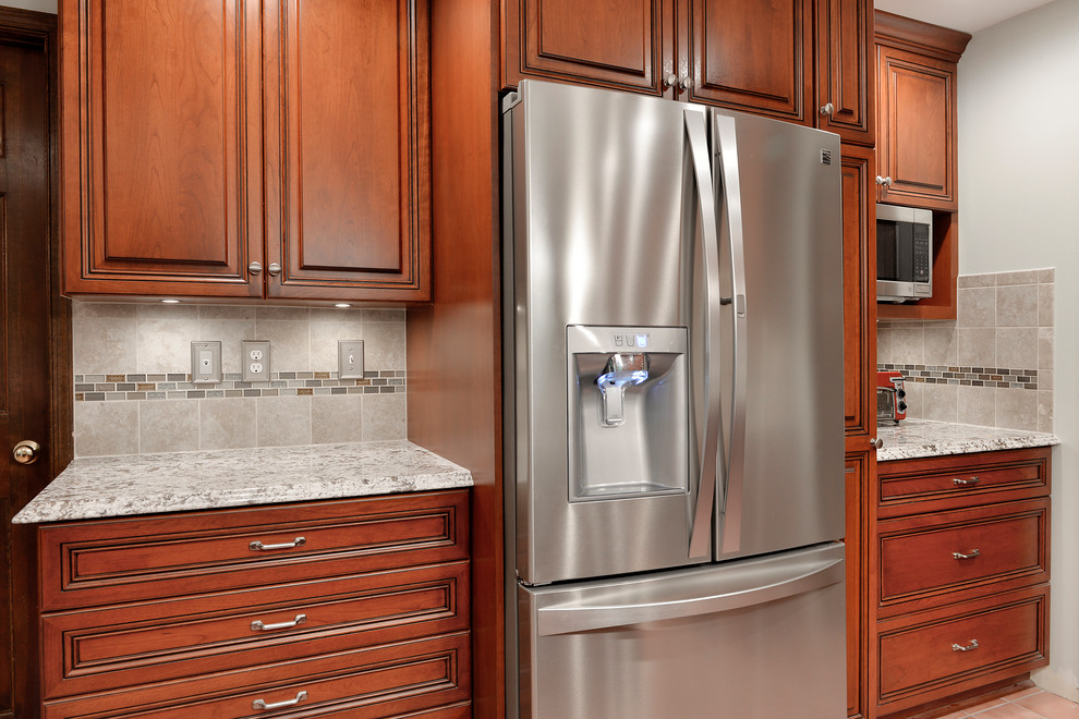 Bild på ett mellanstort vintage grå grått kök, med en undermonterad diskho, luckor med upphöjd panel, skåp i mellenmörkt trä, granitbänkskiva, grått stänkskydd, stänkskydd i keramik, rostfria vitvaror, klinkergolv i keramik, en köksö och rosa golv