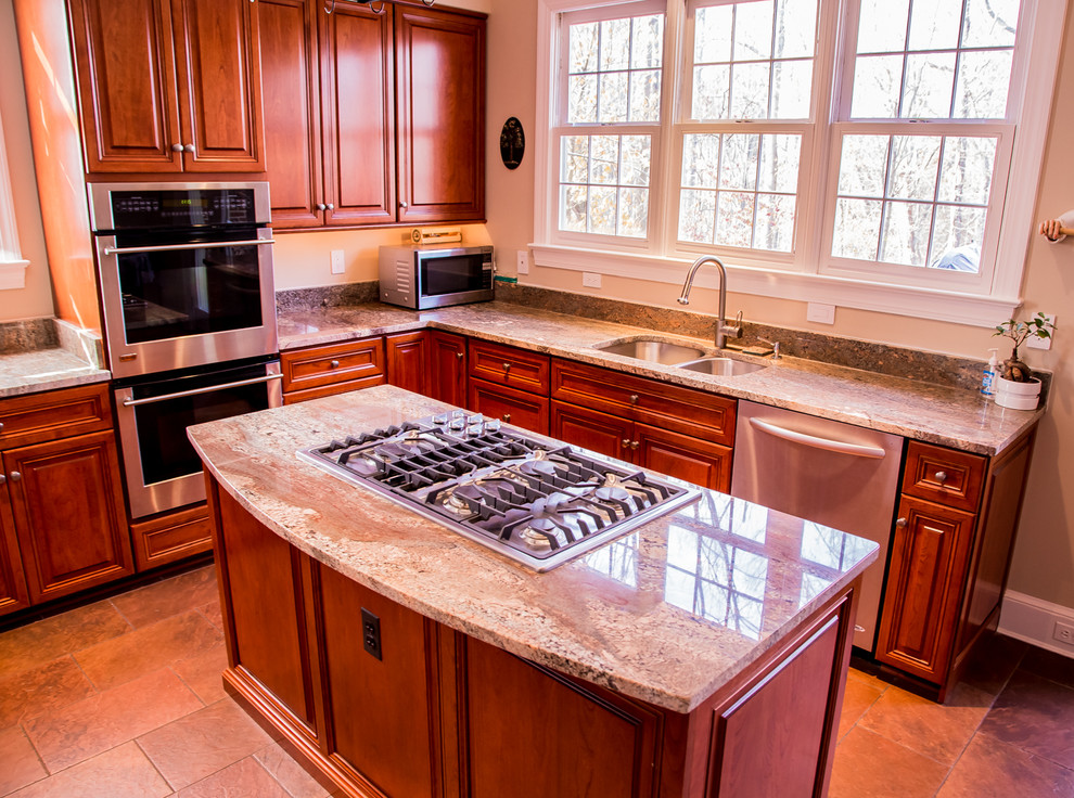 Exempel på ett mellanstort rustikt kök, med en dubbel diskho, luckor med upphöjd panel, skåp i mellenmörkt trä, granitbänkskiva, rostfria vitvaror, klinkergolv i keramik, en köksö och beige stänkskydd