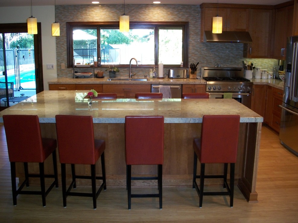Photo of a medium sized classic l-shaped kitchen pantry in Los Angeles with a double-bowl sink, shaker cabinets, red cabinets, marble worktops, white splashback, glass tiled splashback, stainless steel appliances, bamboo flooring and an island.