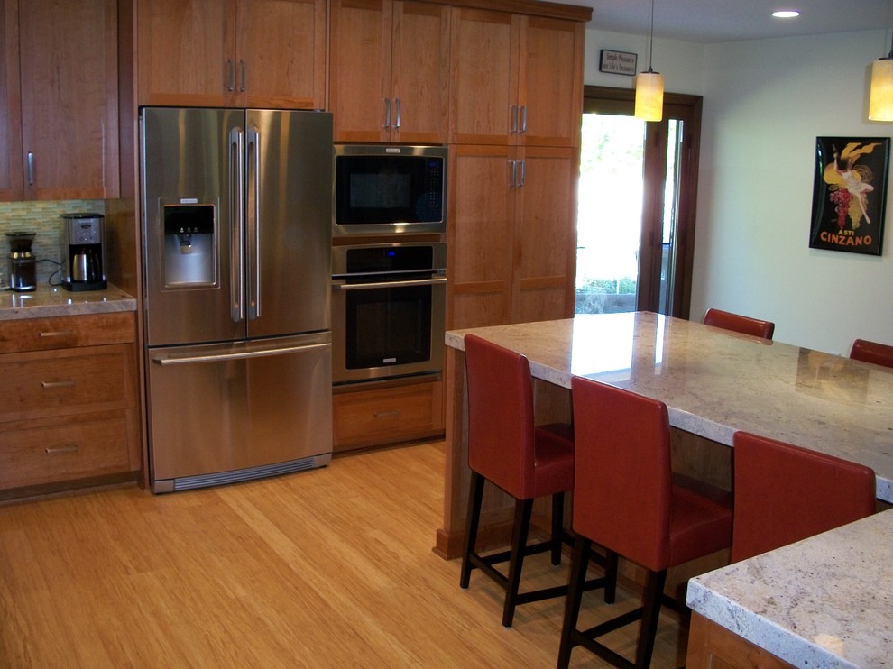 Klassisk inredning av ett mellanstort kök, med en dubbel diskho, skåp i shakerstil, röda skåp, marmorbänkskiva, vitt stänkskydd, stänkskydd i glaskakel, rostfria vitvaror, bambugolv och en köksö