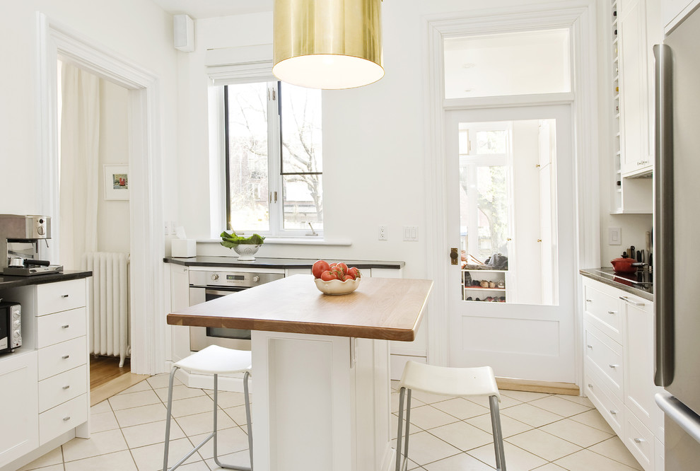 Inspiration för moderna kök, med luckor med infälld panel, träbänkskiva och vita skåp
