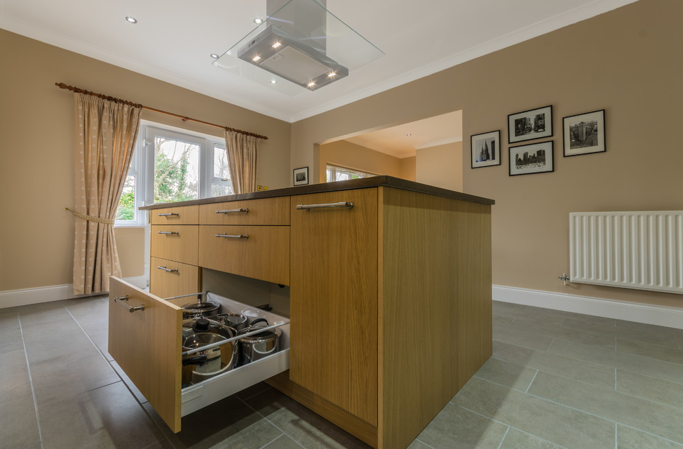 This is an example of a medium sized contemporary l-shaped kitchen/diner in Other with a double-bowl sink, flat-panel cabinets, light wood cabinets, quartz worktops, stainless steel appliances, ceramic flooring and an island.