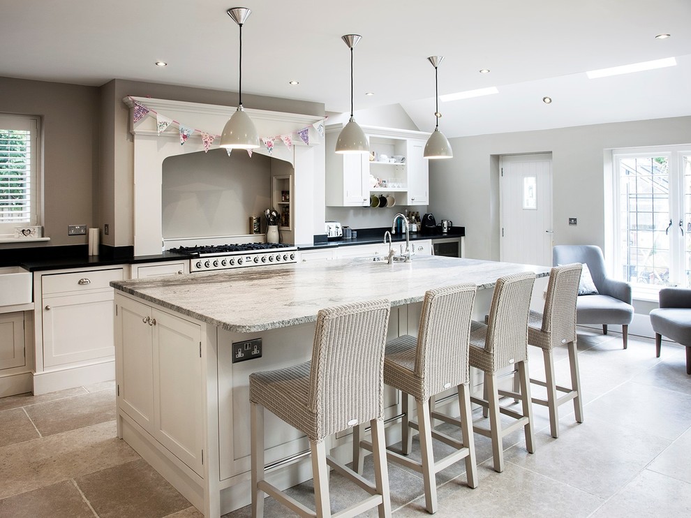 Inspiration for a classic kitchen in Cheshire with a submerged sink, shaker cabinets, beige cabinets, beige splashback, stainless steel appliances, an island, beige floors, granite worktops, limestone flooring and multicoloured worktops.