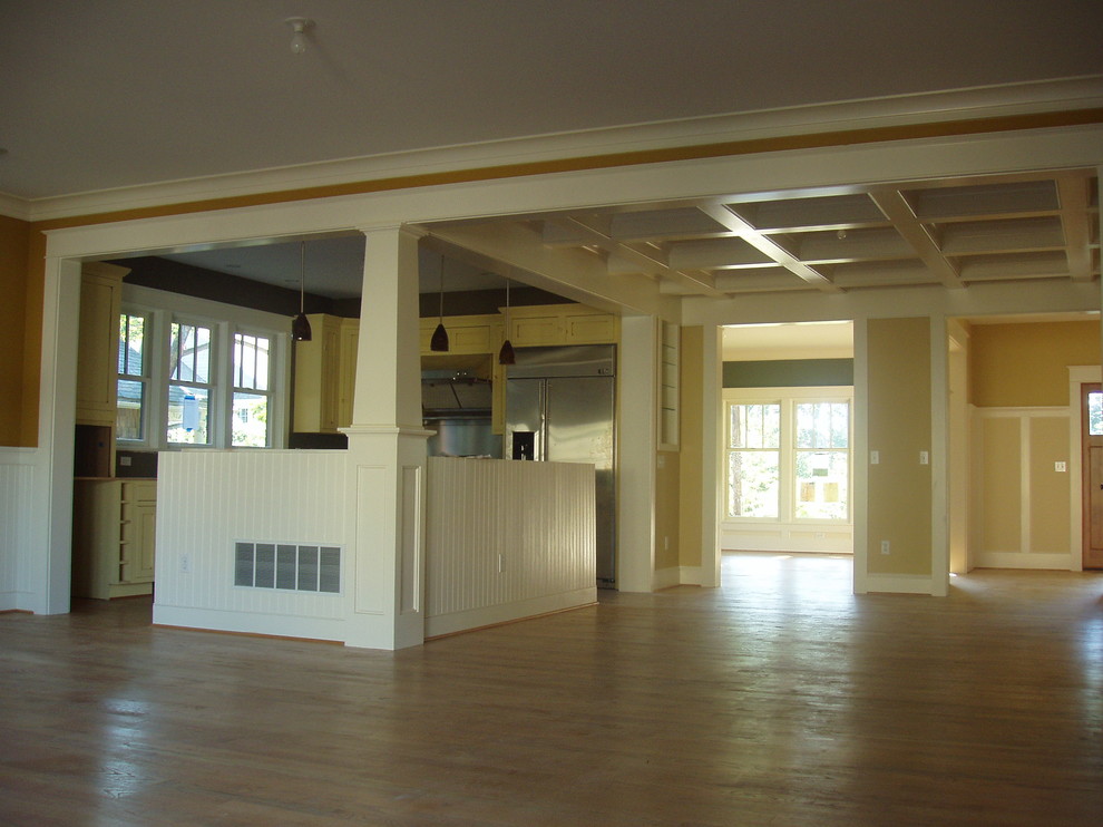 Photo of a medium sized traditional l-shaped kitchen/diner in Baltimore with a submerged sink, recessed-panel cabinets, yellow cabinets, granite worktops, stainless steel appliances, medium hardwood flooring and an island.