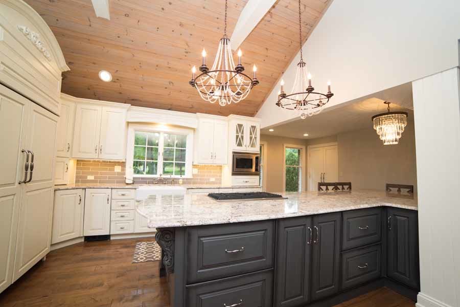 Foto på ett stort lantligt kök, med en rustik diskho, luckor med upphöjd panel, grå skåp, granitbänkskiva, grått stänkskydd, stänkskydd i tunnelbanekakel, integrerade vitvaror, mörkt trägolv och en köksö