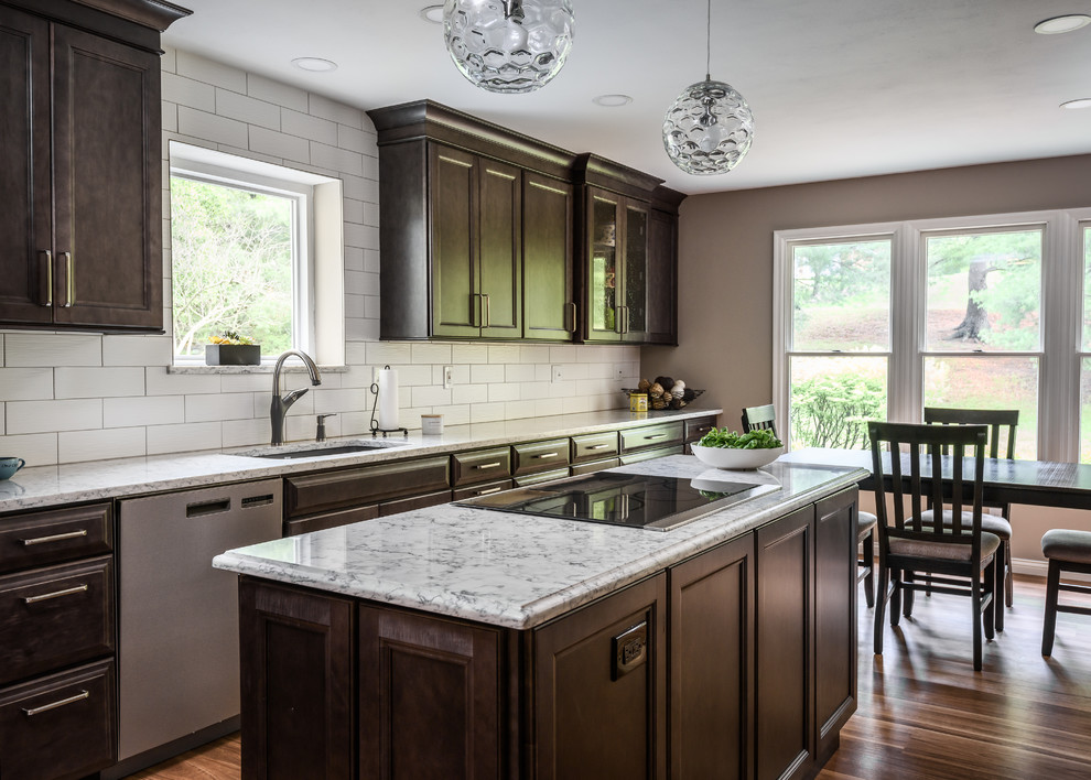 Inredning av ett klassiskt avskilt flerfärgad flerfärgat kök, med en undermonterad diskho, luckor med infälld panel, skåp i mellenmörkt trä, bänkskiva i kvarts, vitt stänkskydd, stänkskydd i keramik, rostfria vitvaror, en köksö och brunt golv