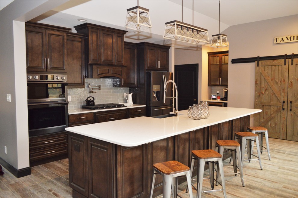 Idéer för stora vintage linjära vitt kök med öppen planlösning, med en rustik diskho, luckor med upphöjd panel, skåp i mörkt trä, bänkskiva i kvartsit, grått stänkskydd, en köksö och stänkskydd i glaskakel