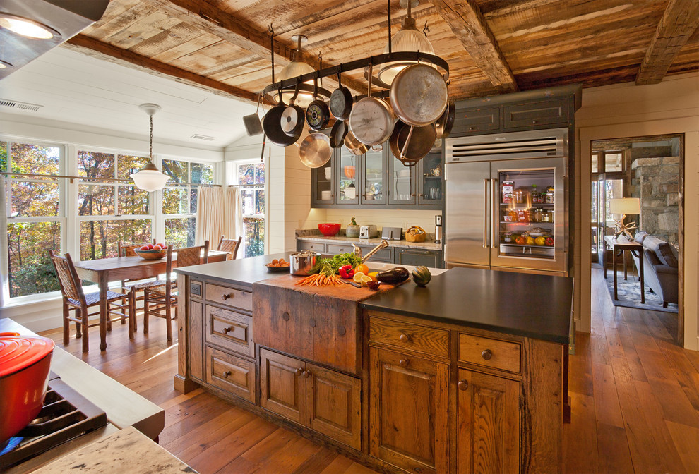 Foto de cocina rústica de roble con electrodomésticos de acero inoxidable y armarios con rebordes decorativos