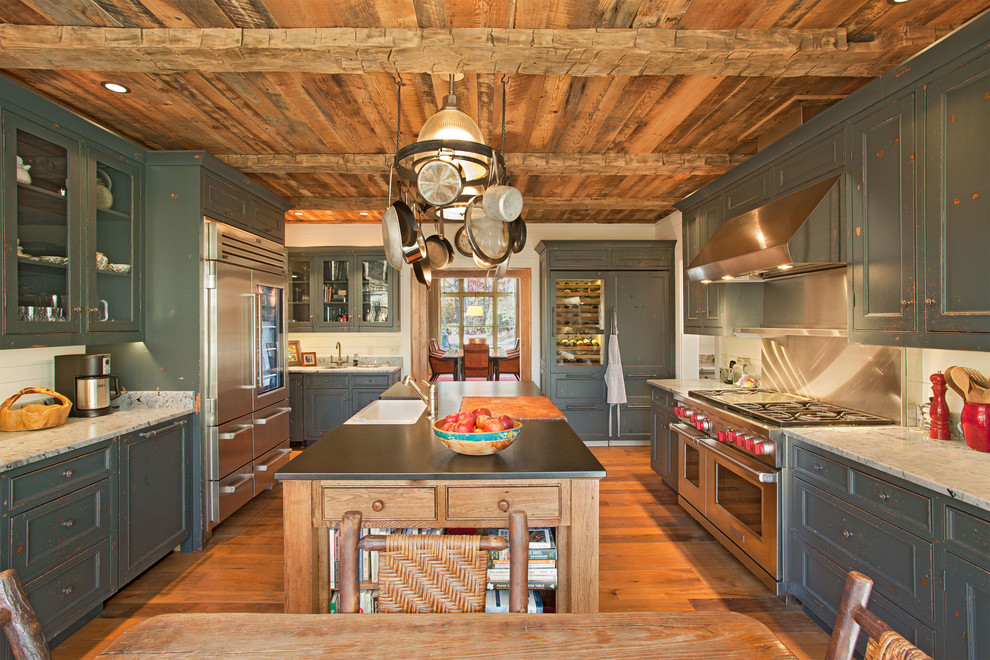 Immagine di una cucina rustica con lavello stile country, elettrodomestici in acciaio inossidabile e struttura in muratura