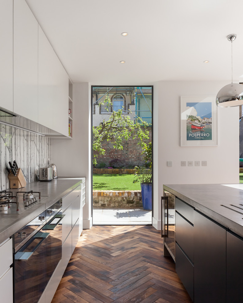 Foto di una cucina minimal con ante lisce, top in cemento, pavimento in legno massello medio e pavimento marrone